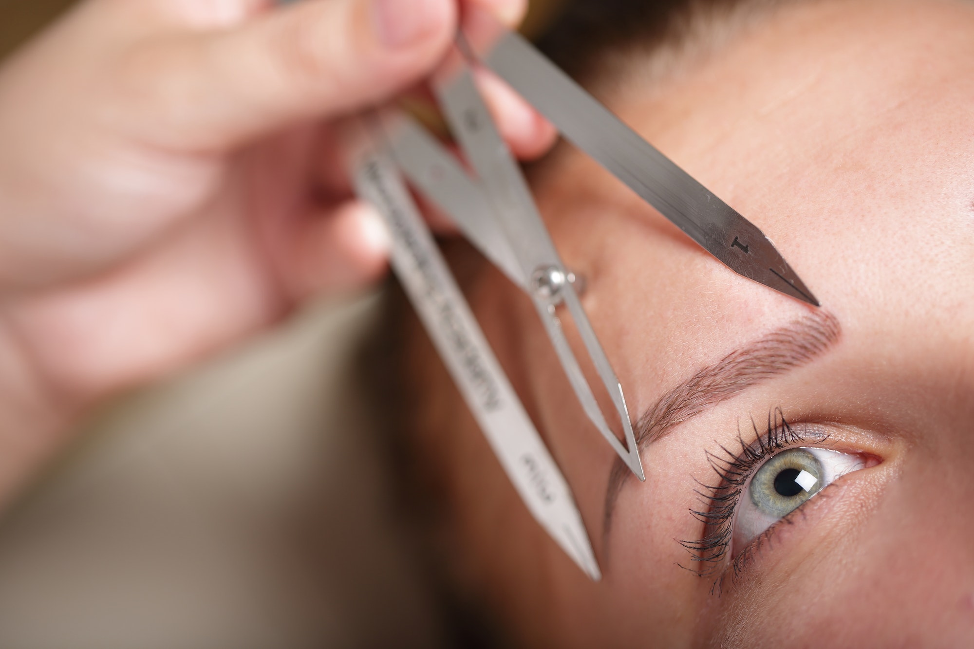 The eyebrows are measured for the treatment